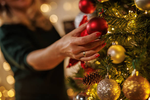 istock Indoor holiday decorating with a woman and a Christmas tree 2187173914