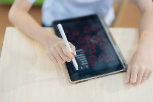 istock A student's hand is focused on her tablet. Her surroundings are filled with warm light and bright colors, perfectly balancing productivity and comfort. 2187174395