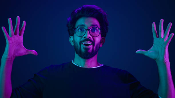 istock Male portrait neon ultraviolet background Arabian man Indian guy coder hacker showing head mind explosion gesture boom brainstorm idea mental shock information think computer technology sci-fi future 2187175477