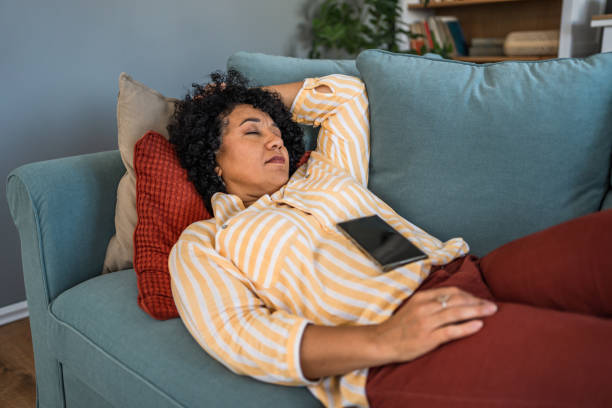 istock Tired woman taking a nap on the sofa 2187177242