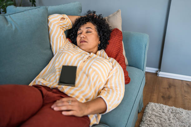 istock Tired woman taking a nap on the sofa 2187177277