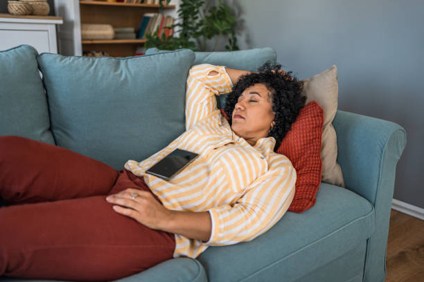 istock Tired woman taking a nap on the sofa 2187177312