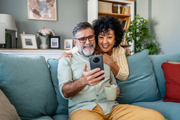 istock Mature couple looking together at mobile phone 2187177906