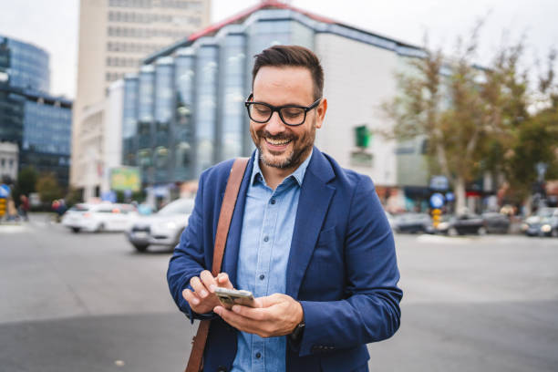 istock businessman walk around city and use mobile phone 2187178505