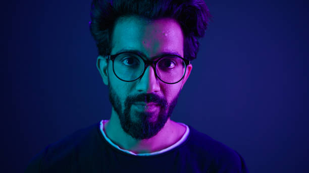 istock Close up portrait Arabian Indian man guy male programmer coder put on glasses 3d dimension focus gesture insight good eye sight vision focused view eyesight computer work in violet neon background 2187179267