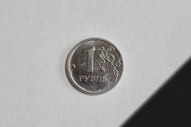 One-ruble coin on a white background with a mourning black ribbon in the upper right corner of the frame, devaluation of the ruble, decline of the Russian economy, inflation of the Russian currency, \