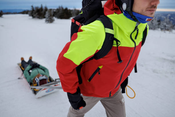 istock Rescue worker transporting injured snowboarder on sled 2187187944