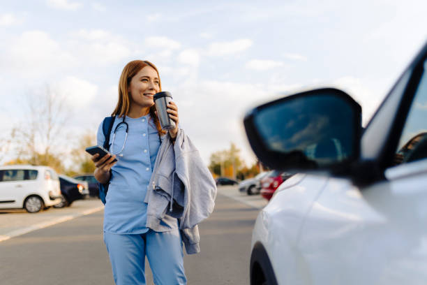 istock Cheerful female nurse uses smartphone while walking to work 2187188945