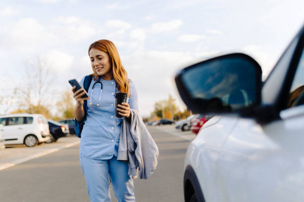 istock Cheerful female nurse uses smartphone while walking to work 2187189610