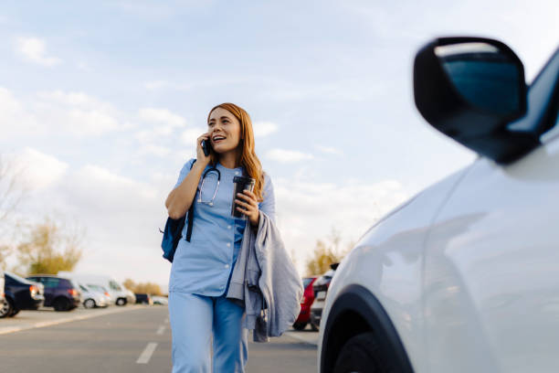 istock Cheerful female nurse uses smartphone while walking to work 2187189975