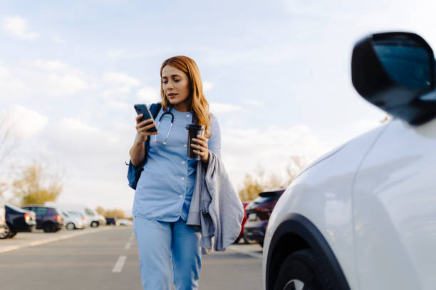 istock Cheerful female nurse uses smartphone while walking to work 2187190598