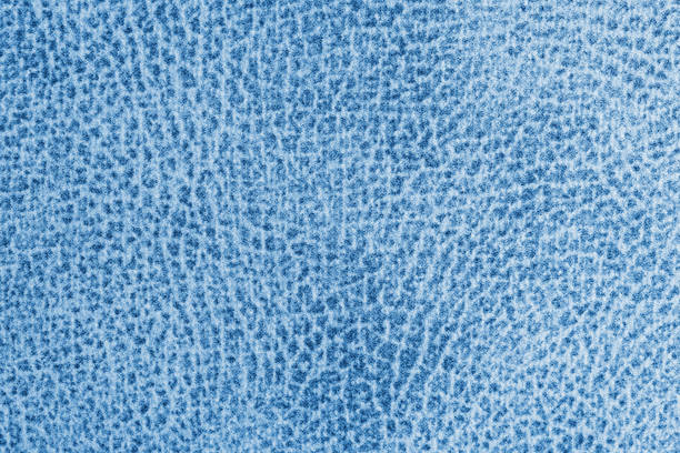 Jacquard blue fabric with abstract shabby spotted print. Close up, macro texture. Upholstery, curtain decorative cloth structure, canvas for home decor. Background, backdrop, wallpaper.