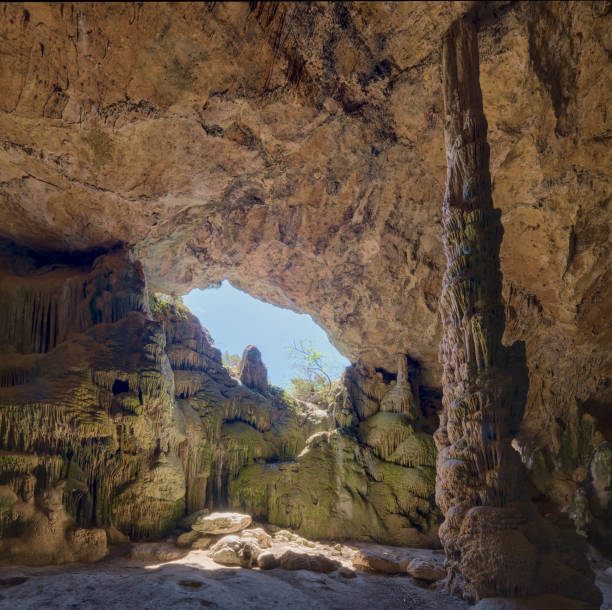istock The image showcases a natural cave with sunlight streaming through an opening, highlighting intricate rock formations. 2187191301