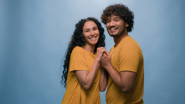 istock Blue studio background happy multiracial couple showing heart shape St Valentines Day romantic relationships love married man and woman sincere feelings followers kindness volunteering Ukraine support 2187191793