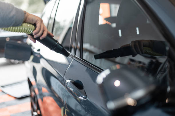 istock Professional Man Washes Car and Dries with Tool from Drops at Car Wash. Auto Detailing 2187192122