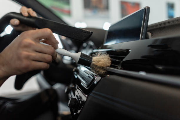 istock Professional man cleaning car dashboard with brush. Detailing 2187192224