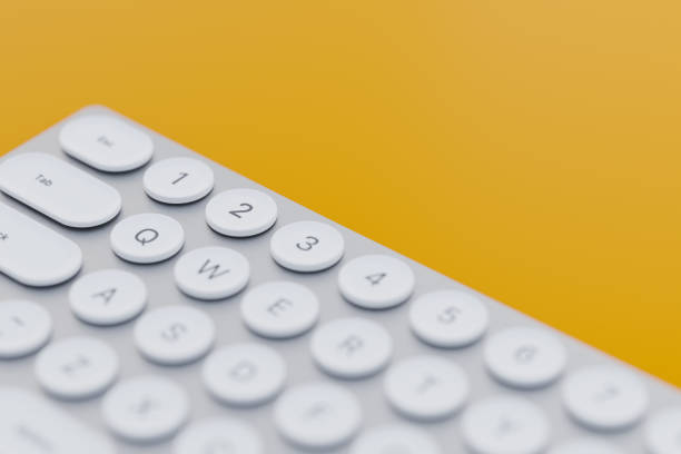 A close-up image of a modern white keyboard with round keys set against a vibrant orange background, showcasing minimalistic design and technology.