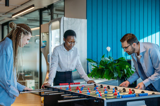 istock Colleagues Engaged in a Fun Table Football Game at the Office 2187194002