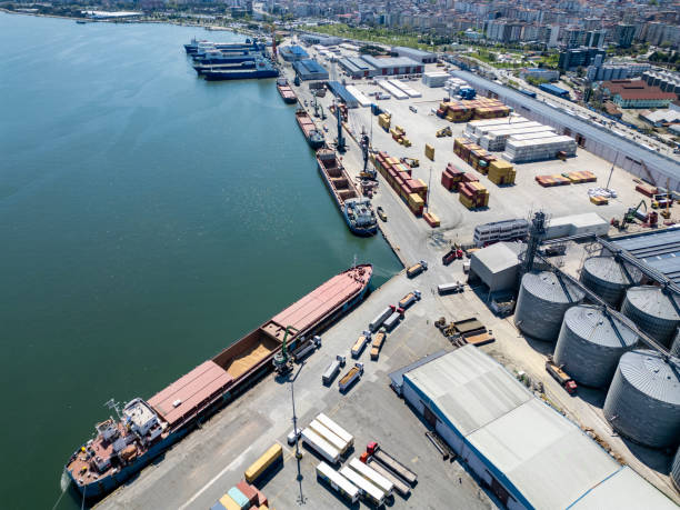 istock Loading operations with a portal crane in a warehouse in the port.Grain transshipment from cargo ship to truck holds 2187194892