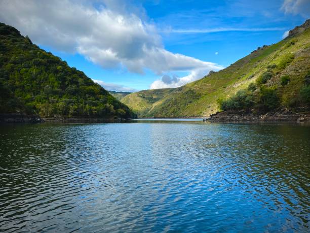 Picturesque river meandering through mountains and hills, creating a serene summer landscape.