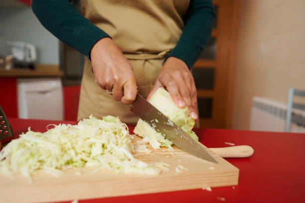 istock Person chopping fresh cabbage on wooden cutting board 2187201082