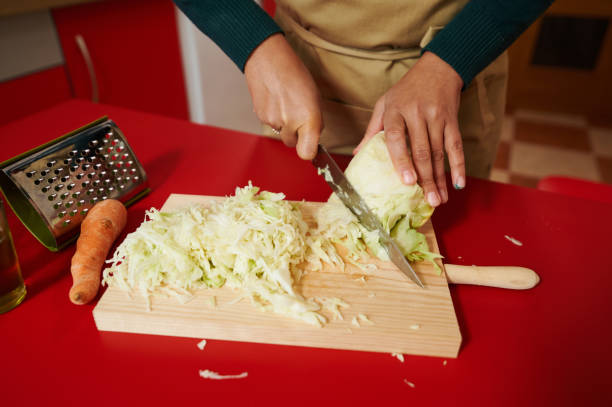 istock Person chopping fresh cabbage on a red kitchen countertop 2187201122