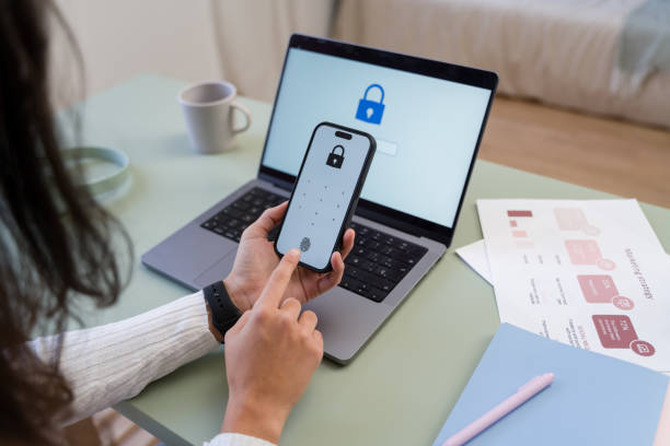 istock Businesswoman using fingerprint scanner on smartphone for secure access to laptop 2187202695