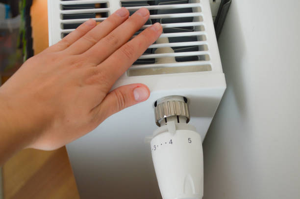 istock Adjusting Radiator Thermostat at Home 2187204490
