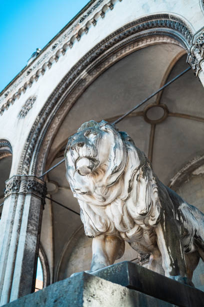 Feral Pigeon on Medici Lion at Loggia dei Lanzi at Florence in Tuscany, Italy. This sculpture is in a public space on on Piazza della Signoria.