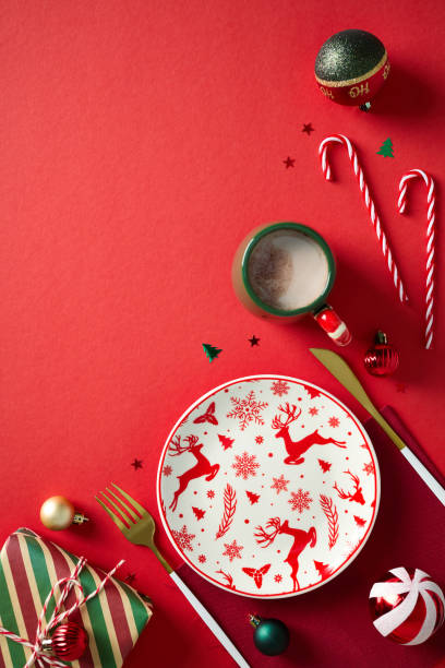 istock Christmas table setting with Xmas decorations, empty plate, golden cutlery on red background. Flat lay, top view. 2187210617
