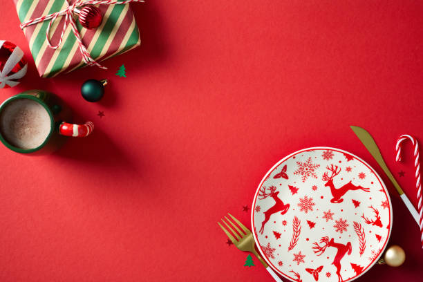 istock Christmas table setting with empty plate, gift box, cacao cup, Xmas decorations on red background 2187210697