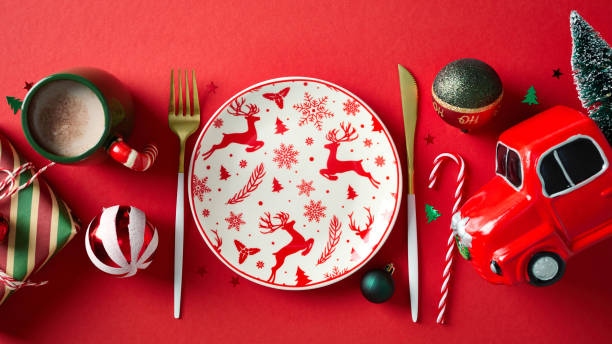 istock Christmas table setting with empty reindeer pattern plate, golden cutlery, vintage gift box, baubles on red background. Flat lay, tp view, copy space 2187210706