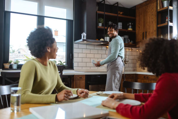 istock Happy family at the dinning table in the kitchen 2187210958