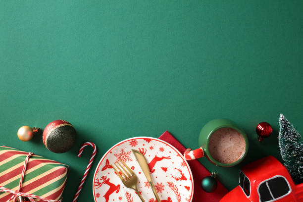 istock Christmas table setting with red reindeer plate, hot chocolate, and festive decorations on green background 2187211155