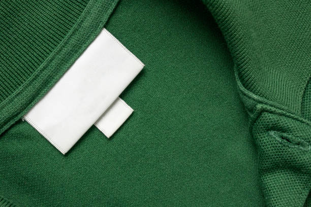 istock Blank white laundry care clothes label on green shirt fabric texture background 2187215088