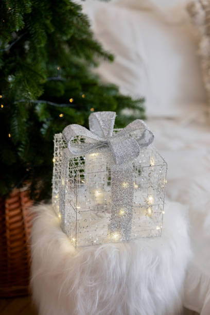 istock Elegant lighted gift box under a Christmas tree at a cozy home setting 2187215837