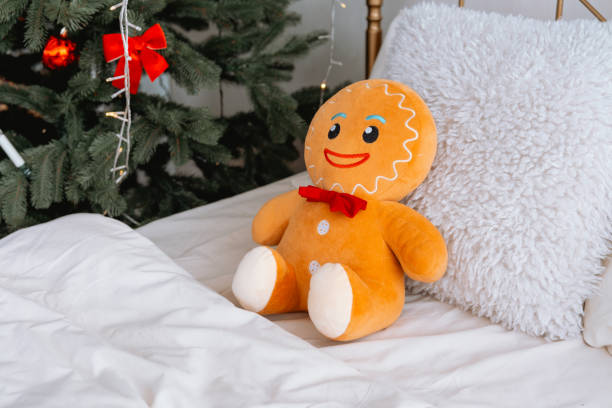 istock Cute gingerbread plush toy sitting on a cozy bed during Christmas time 2187215850