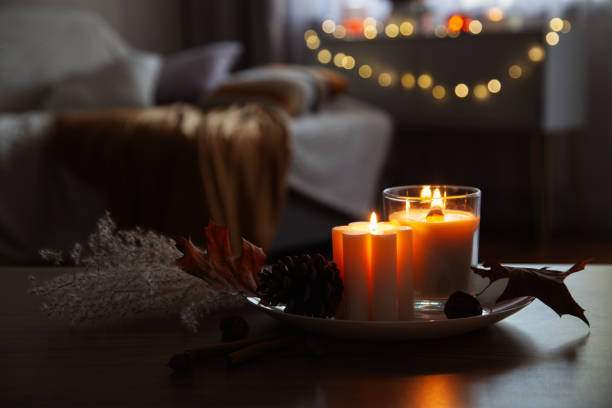 autumn and winter home decor with burning candles stock photo