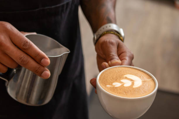 Barista pouring latte art in coffee cup