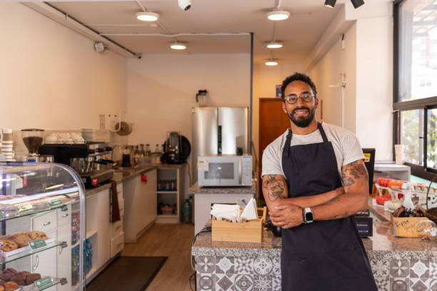 istock Confident barista smiling at camera in his coffee shop 2187219256
