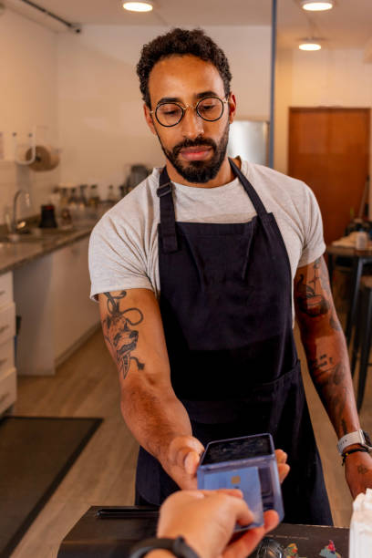 istock Barista accepting contactless payment from customer in coffee shop 2187219263