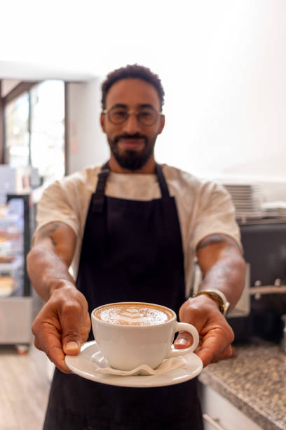 istock Barista offering cappuccino in coffee shop 2187219270