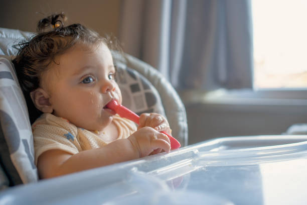 istock Thoughtful Baby Holding Spoon by the Window 2187229135