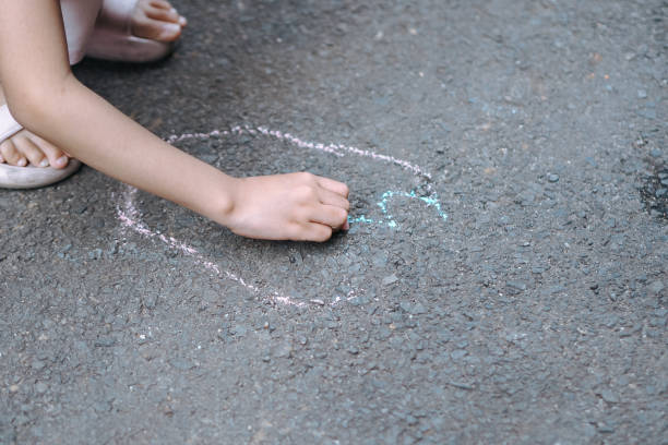 istock A child producing artwork with chalk on his driveway 2187231294