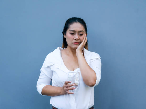 istock Asian woman feel sensitive teeth after drinking cold. Dental health problems. Front view 2187232613