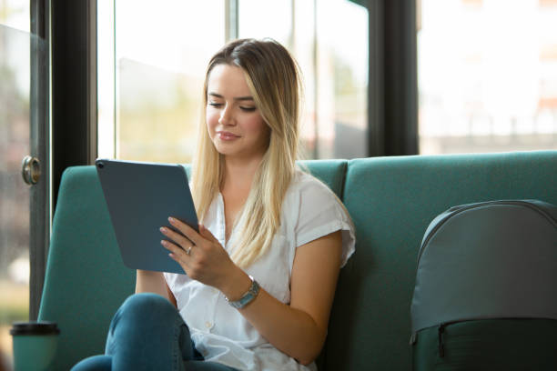 istock Young Beautiful Blonde Woman Working on Digital Tablet in Modern Cafe Setting 2187232939