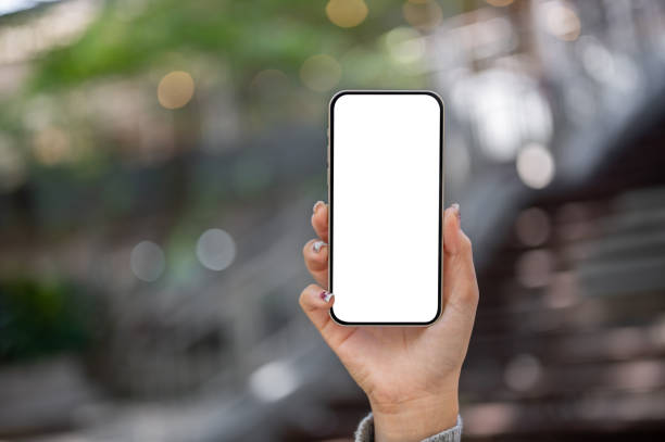 istock A woman's hand holding a smartphone with a white screen mockup, showing it toward the camera. 2187234232