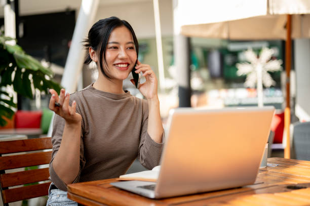 istock A beautiful Asian woman talking on the phone while working remotely from a cafe. 2187234606