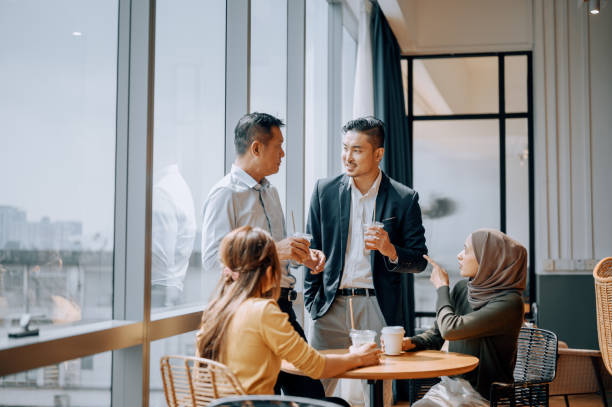 istock Coffee break Asian white collar colleague discussion with window background 2187240800