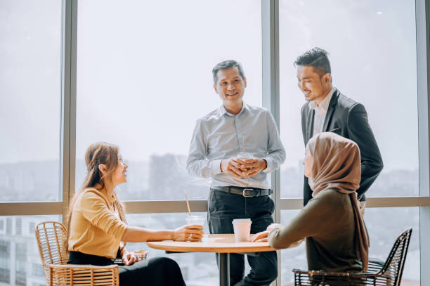 istock Coffee break Asian white collar colleague discussion with window background 2187240804